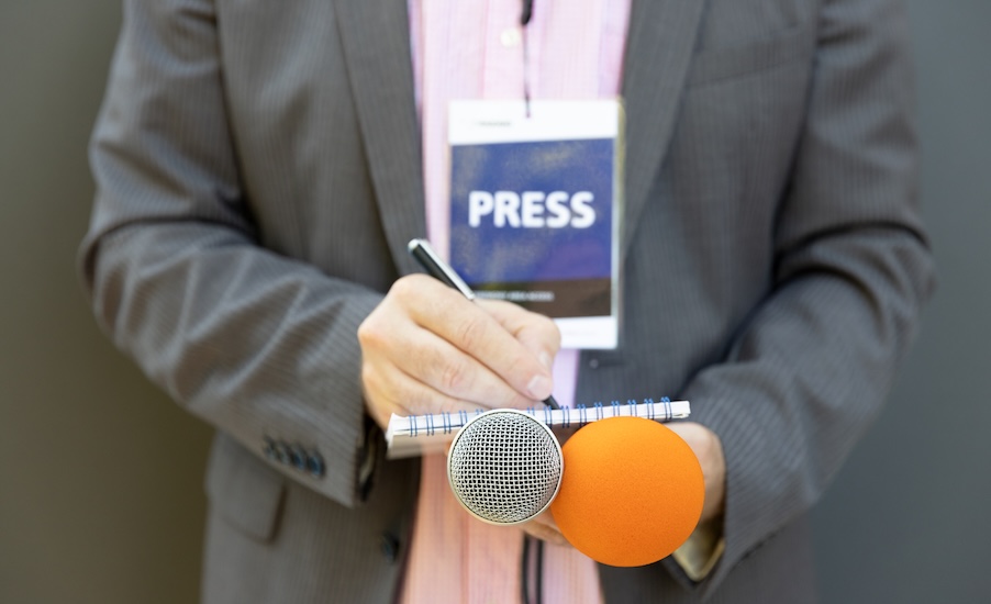 Journalist at press conference event writing notes